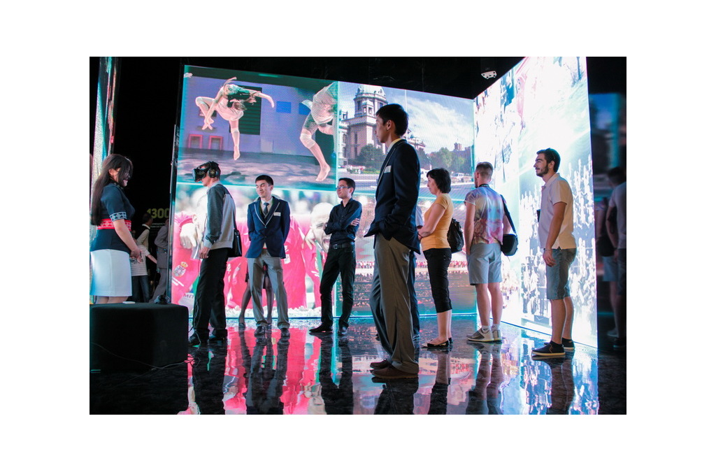 Visitors engage with an interactive display showcasing Serbia's athletic prowess at the World Expo Astana 2017, using IR motion sensors for immersive experiences.